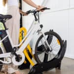 woman putting a bike in a Velo floor mount rack